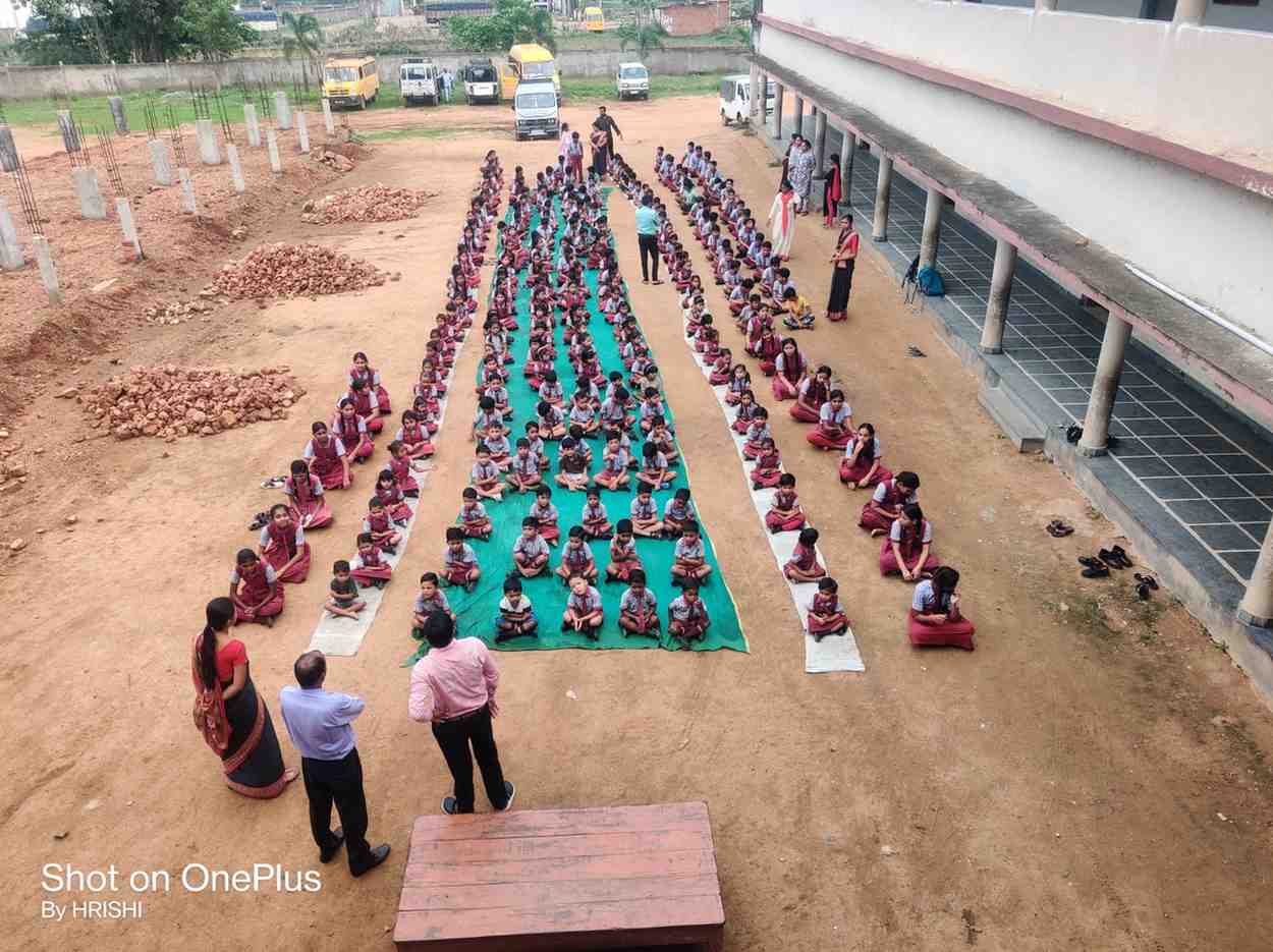 विद्यालय में अंतरराष्ट्रीय योग दिवस के अवसर पर सामूहिक योग अभ्यास करते विद्यार्थी
